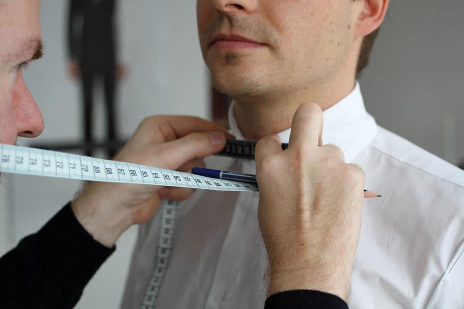 Bespoke tailor Egon Brandstetter taking measurements for a custom dress shirt